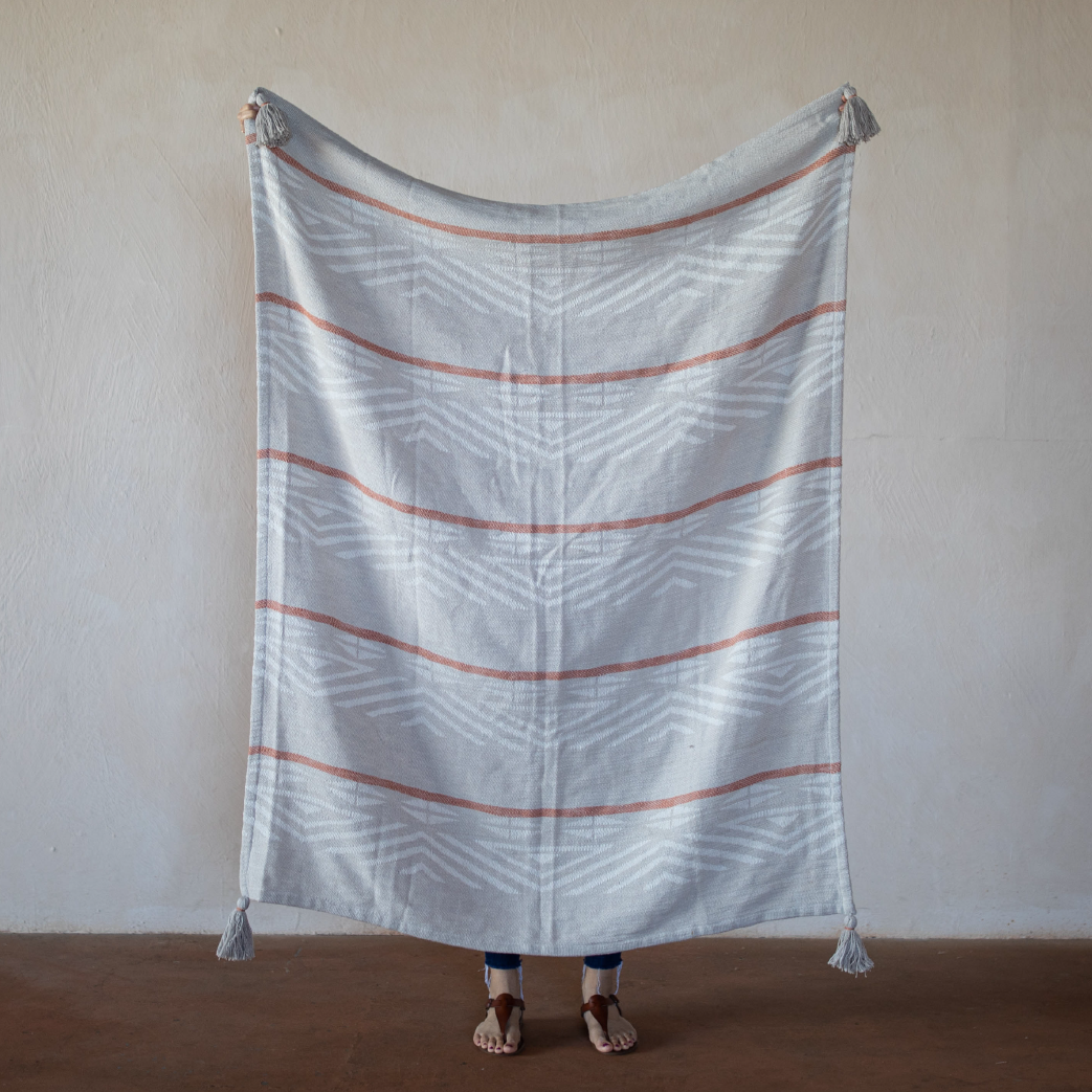 terracotta colored throw blanket being held up